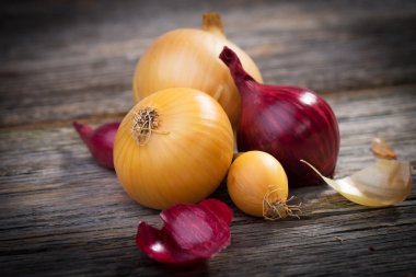 Fresh onions on a wooden background clipart