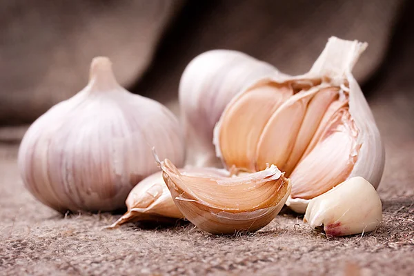 Fragrant garlic on background of coarse cloth — Stock Photo, Image