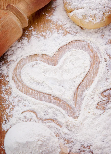 Coração desenhado com farinha na mesa da cozinha — Fotografia de Stock