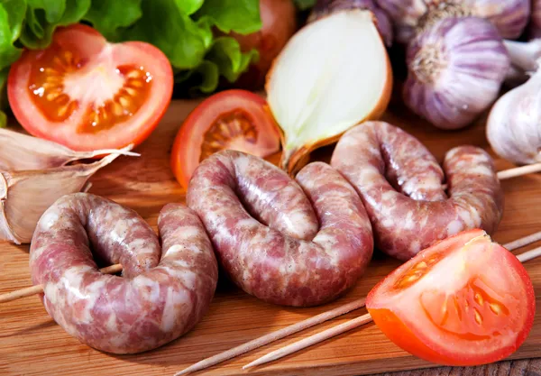 Sausage, garlic, tomatoes, lettuce, onions — Stock Photo, Image