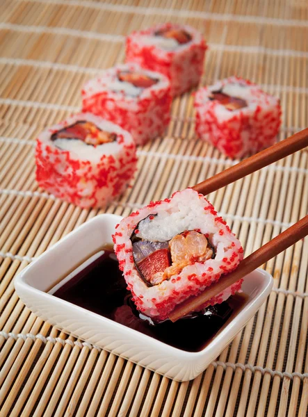 O conceito de comida japonesa - sushi e molho de soja no tapete — Fotografia de Stock