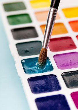 suluboya resimler ve masadaki fırça.