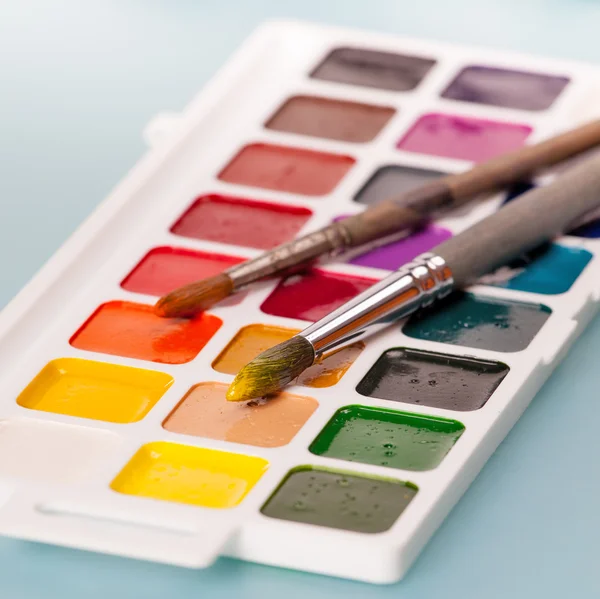 Aquarellfarben und Pinsel auf dem Tisch — Stockfoto