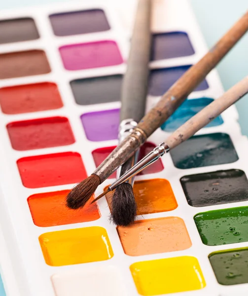 Watercolor paints and brush on the table — Stock Photo, Image