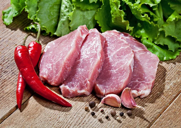 Carne fresca, ensalada y especias sobre la mesa — Foto de Stock