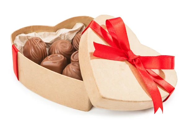 Шоколадні цукерки в коробці з червоним бантом — стокове фото