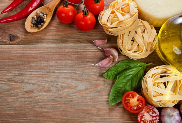 イタリア料理。野菜、オイル、スパイス、パスタ、テーブルの上 ロイヤリティフリーのストック画像