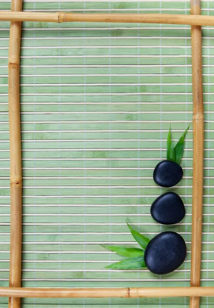 Bamboo frame and black stones — Stock Photo, Image