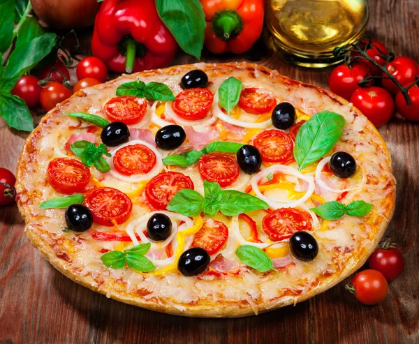 Tasty pizza and fresh ingredients on the table — Stock Photo, Image