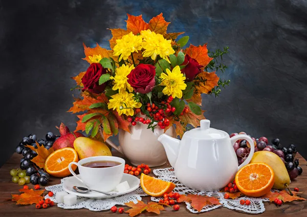 Осенний натюрморт. Чай, цветы и желтые листья — стоковое фото