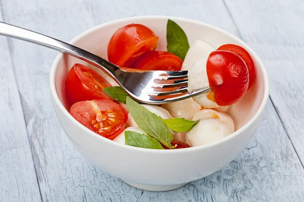 Ensalada Caprese con mozzarella, tomate, albahaca en tazón blanco —  Fotos de Stock