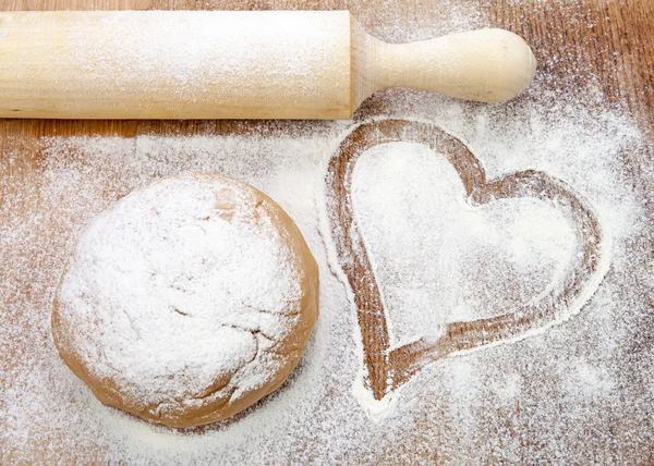 Dough and heart of flour on wooden desk — Stock Photo, Image