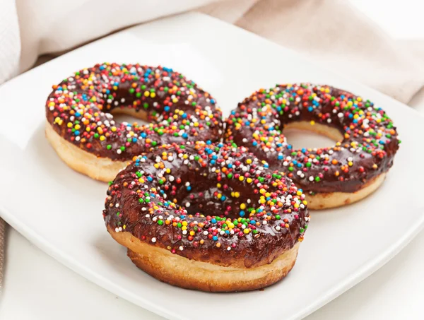 Donuts with chocolate on a plate — Stock Photo, Image