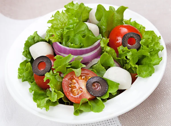 Alimento dietético - ensalada fresca en un plato sobre la mesa —  Fotos de Stock