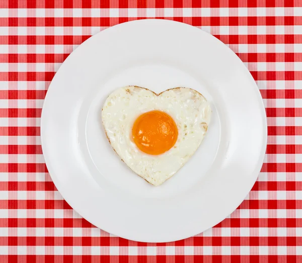 Tojás a szív alakú szolgált egy tányérra az asztalon — Stock Fotó
