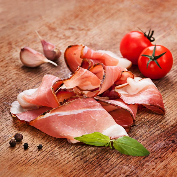 Slices of tasty spanish ham on board — Stock Photo, Image