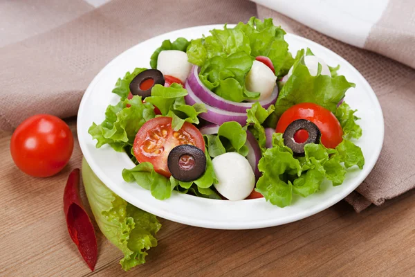 Alimento dietético - ensalada fresca en un plato sobre la mesa — Foto de Stock