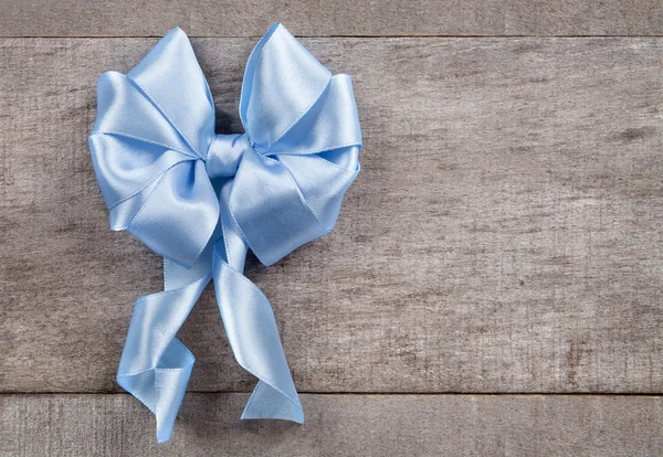 Blue bow on old boards — Stock Photo, Image