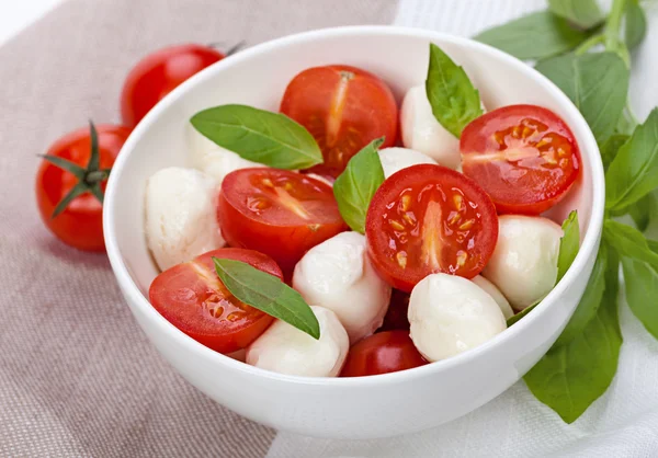 Caprese-Salat mit Mozzarella, Tomate, Basilikum auf weißem Teller — Stockfoto