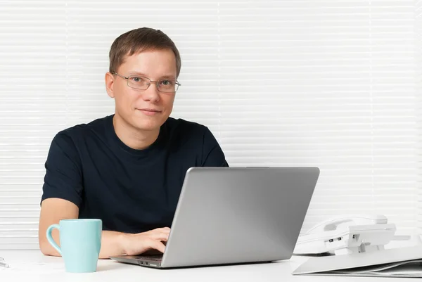 Man med en laptop på skrivbordet — Stockfoto