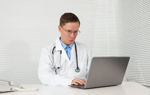 그의 노트북 컴퓨터에 작동 하는 남자 의사 — 스톡 사진