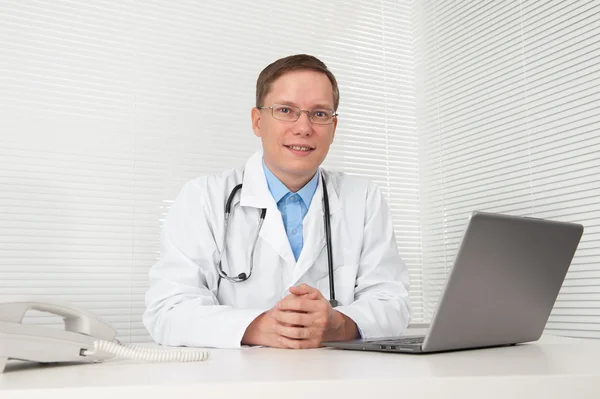 Лікар з ноутбуком за столом в офісі — стокове фото