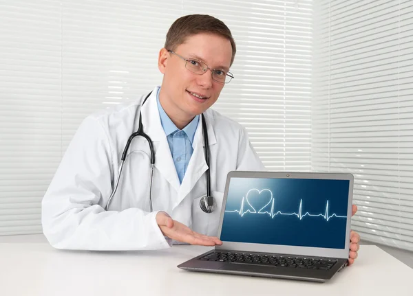 Jovem médico em jaleco com laptop — Fotografia de Stock