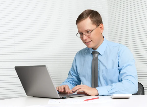 Young business man working on computer at office desk — Stock Photo, Image