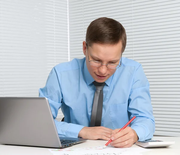 Geschäftsmann schreibt auf Papierkram und arbeitet mit Laptop in seinem — Stockfoto