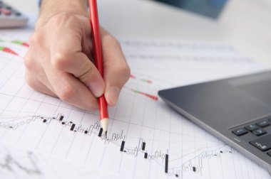 hisse senedi grafikleri gösteren bir erkek el