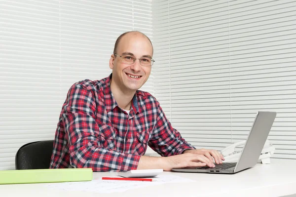 Happy young man using a laptop - Indoor Royalty Free Stock Photos
