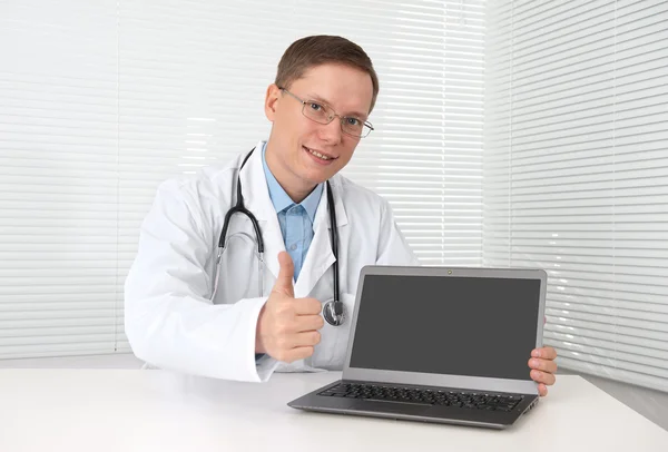 Médico com computador portátil mostrando polegares para cima — Fotografia de Stock