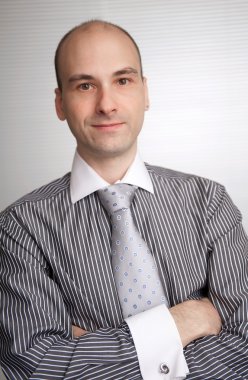 elleri ile ayakta gülümseyen genç işadamı portresi