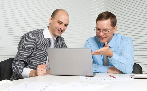 Zwei Geschäftsleute arbeiten an einem Laptop — Stockfoto
