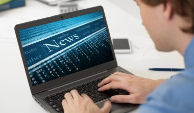 işadamı onun laptop üzerinde Business haber okuma