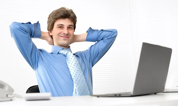 Smiling handsome businessman relaxing in a office — Stock Photo, Image