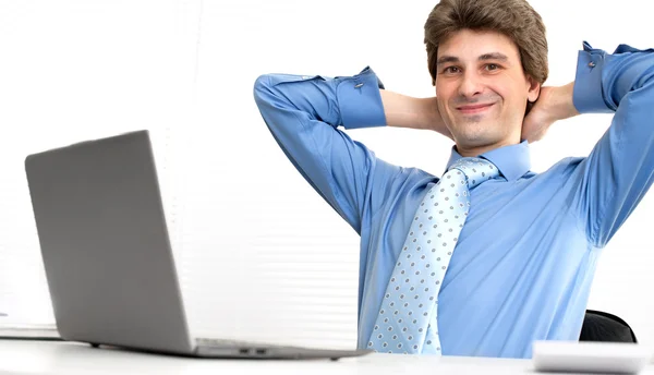 Smiling handsome businessman relaxing in a office — Stock Photo, Image