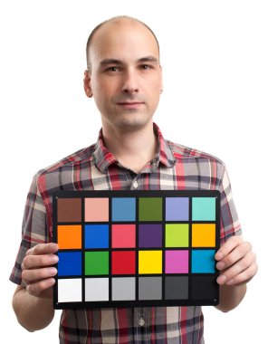 man holds an white balance card with test colors clipart