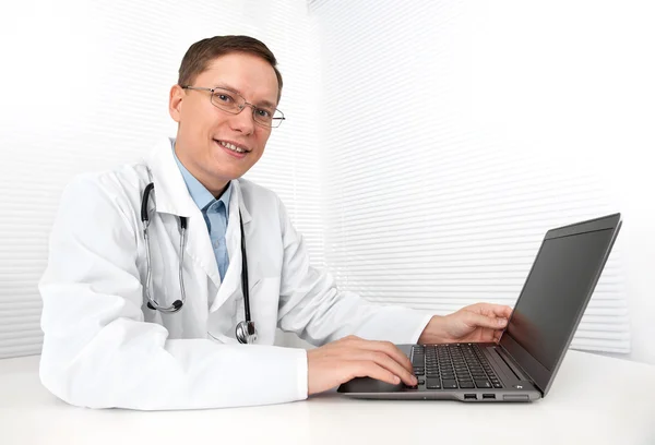 Homme médecin travaillant sur un ordinateur portable Photo De Stock