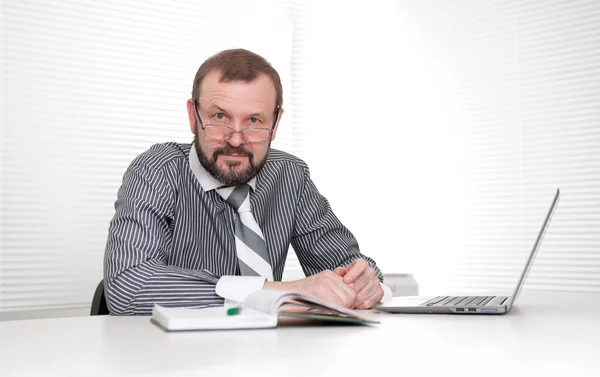 Seniorunternehmer sitzt an seinem Schreibtisch im Büro — Stockfoto