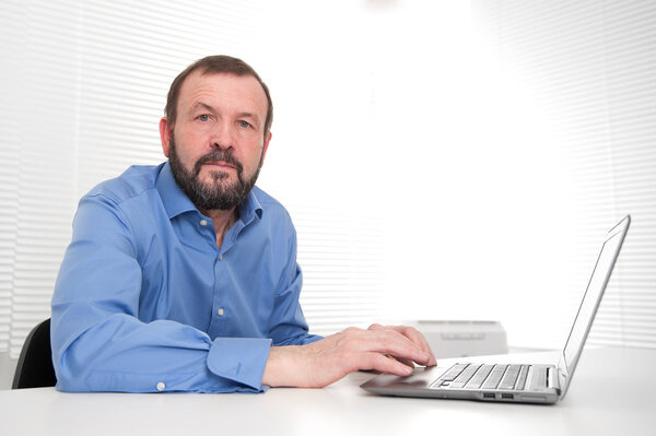 senior business man sitting by his laptop in the office