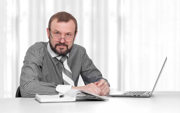 Senior business man sitter vid sitt skrivbord på kontoret — Stockfoto