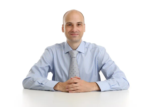 Усміхнений бізнесмен сидить за своїм столом ізольовано над білою спиною — стокове фото