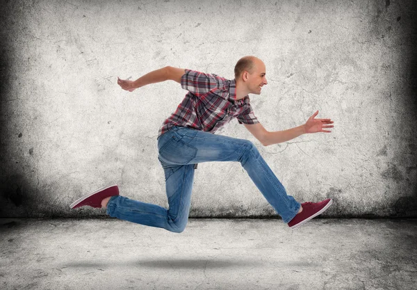 Homem a correr. Parede de concreto cinza e piso — Fotografia de Stock