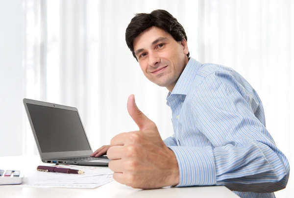 Бизнесмен показывает свой большой палец в офисе — стоковое фото