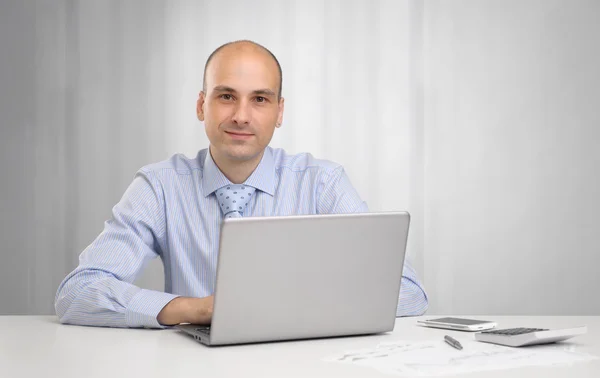 Bello uomo d'affari seduto alla scrivania in ufficio, a lavorare sul lapto — Foto Stock