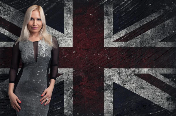 Mooie blonde vrouw boven grungy Britse vlag — Stockfoto