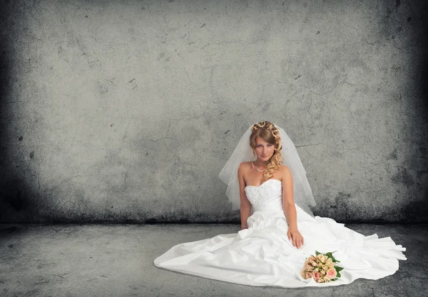 Noiva em um vestido de casamento em um piso de concreto cinza — Fotografia de Stock