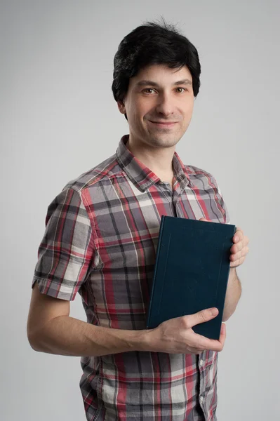 Man with a book on grey background — Stock Photo, Image