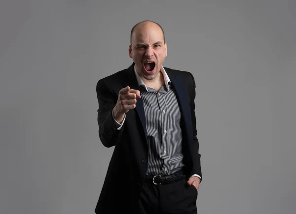 Angry man pointing his finger against somebody — Stock Photo, Image